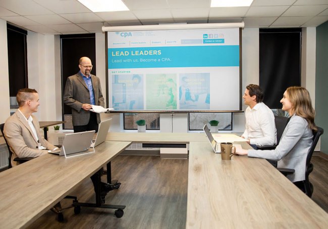 Diverse Modern Office: Businessman Leads Business Meeting with Managers, Talks, uses Presentation TV to discuss program options.