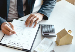 Man reviewing contract with a stack of money and keys